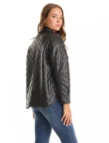 Chaqueta tipo camisa (shacket) de eco cuero color beige, con diseño acolchado en rombos, cuello camisero, botones frontales y dos bolsillos de parche en el pecho.