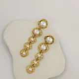 Aros colgantes largos dorados con cinco perlas de imitación de diferentes tamaños. Cierre con tuerca a presión.