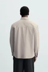 Camisa relaxed fit confeccionada en tejido con mezcla de algodón con tacto suave. Cuello solapa y manga larga acaba en puño con botón. Bolsillo plastrón en pecho. Cierre frontal de botonadura.