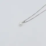 Conjunto de collar y aros de plata 925 con perlas de río blancas. El collar tiene una cadena de eslabones cuadrados y un dije con una perla. Los aros son colgantes con una perla cada uno.