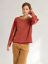 Buzo de lana color rojo y rosa con diseño moderno en las mangas, que proporciona calidez sin sobrecalentar.