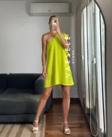 Vestido corto color verde lima, con escote asimétrico a un hombro, volado en el hombro y elástico en el borde superior.