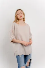 Blusa color beige confeccionada en lino, de corte holgado, mangas 3/4 y cuello redondo.