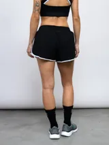 Short deportivo gris con ribetes celestes en ruedo y cintura.