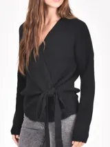 Buzo de tejido de punto negro, con escote en V y diseño cruzado que se ata con un lazo ancho a la cintura. Presenta mangas largas y puños acanalados.