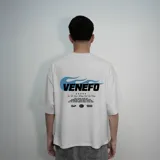 Remera blanca de algodón con corte oversize y estampado en la espalda con el logo "Venefo" y texto en color celeste.
