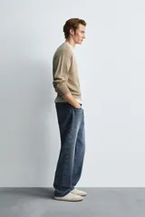 Jersey de hombre color beige, de corte relaxed fit, tejido en hilatura con algodón y ramio. Tiene cuello pico, manga larga y acabados en rib.