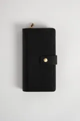 Billetera negra con textura, cierre con broche dorado y compartimento con cierre de cremallera.