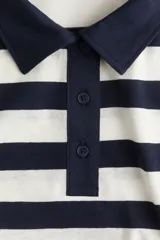 Remera polo de manga larga con cuello clásico y tapeta de botones. Diseño a rayas horizontales blancas y azul marino.