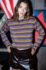 Sweater tejido en mezcla de hilo con lurex, con rayas horizontales color violeta, dorado y marrón. Diseño crop oversize con calce relajado y hombro caído.