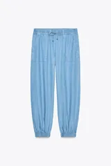 Pantalón jogger celeste confeccionado en lino, con tiro alto, cintura elástica ajustable con cordón, bolsillos delanteros y puños elásticos en el bajo.
