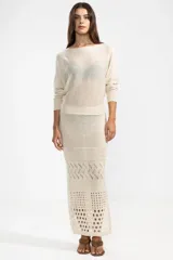 Falda midi color crema, tejida a crochet con aberturas en la parte inferior.