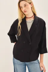 Saco corto de lino negro, de corte oversize con mangas amplias y cruce frontal con doble abotonadura.
