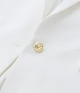 Blazer de poliéster color blanco, de corte sastrero, con cuello solapa, botón dorado redondo contrastante, manga larga con botón y bolsillos fake de solapa delanteros.