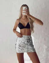 Minifalda plateada con lentejuelas plateadas y negras, de tiro alto y corte ajustado.
