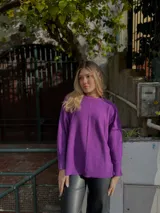 Sweater verde lima de tejido de punto, corte oversize, con tajos laterales y más largo en la parte trasera.