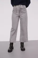 Pantalón de jean azul oscuro, de corte recto y tiro alto, con bolsillos delanteros y traseros de parche.