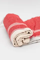 Lona de playa rectangular con diseño estampado a rayas rojas y blancas.