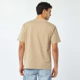 Remera beige de corte recto y cuello redondo.