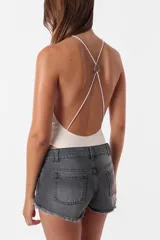 Short de jean gris oscuro, tiro medio, con ruedo desflecado, pasacintos, cierre y botón metálico.