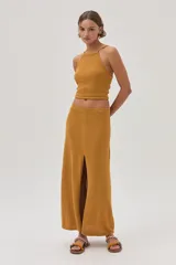 Falda midi color mostaza, tejida con textura y corte en el frente.