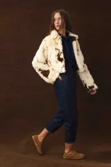 Chaqueta corta de piel sintética con estampado animal print de vaca en tonos crema y marrón.
