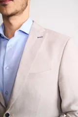 Saco sport color beige claro, de corte clásico, con solapa de muesca, dos botones frontales, bolsillos laterales con solapa y bolsillo en el pecho.