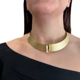 Gargantilla rígida dorada con trama delicada y cristal Swarovski engarzado. Cierre de mosquetón con cadena para regular el largo.