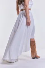 Pollera blanca de corte irregular, más corta en el frente y más larga en la parte trasera, con cintura elastizada.