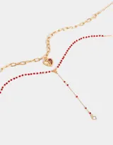 Set de dos collares dorados: uno con cadena de eslabones gruesos y dije de corazón esmaltado en rojo, y otro con cadena de cuentas rojas y dije de strass.