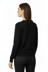 Buzo de corte amplio color marfil con cuello redondo y mangas largas.