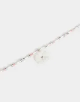 Collar corto de cuentas blancas, celestes y rosadas, con dije de flor blanca con centro azul, dije de caracol y dije de corazón dorado.