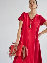 Vestido largo rojo de tejido de punto, con cuello en V y mangas cortas. Presenta costuras verticales a lo largo del vestido.