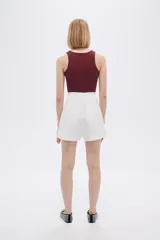 Body blanco sin mangas de poliamida, liso, al cuerpo, con broches y cuello halter.