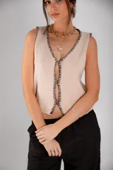 Chaleco tejido celeste con terminaciones en punto festón negro.