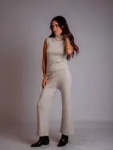 Conjunto de chaleco y pantalón tejido color beige. El chaleco es sin mangas y con cuello alto. El pantalón es de corte ancho.