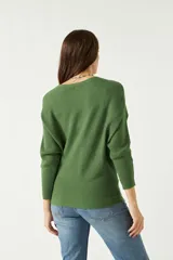Sweater verde de punto liviano con textura acanalada y diseño de hombros caídos.