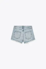 Short de jean negro con lavado gastado y pequeñas estrellas blancas estampadas. Tiene tiro alto, corte recto y terminación desflecada.