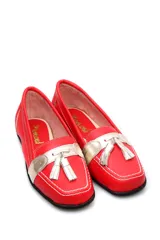 Mocasín de cuero rojo con detalle de pompón y terminación metalizada.
