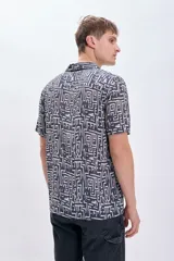 Camisa casual de viscosa con estampado geométrico en tonos blanco y negro, de manga corta y cuello americano.