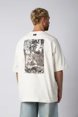 Remera color crudo de corte oversize con estampado pequeño en el centro del pecho.