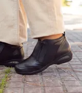 Zapato marrón de cuero con cierre de cremallera lateral y elástico en los laterales.