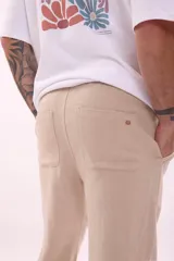 Pantalón de jogging color beige, de corte recto y tiro medio, con cintura elástica ajustable con cordón.