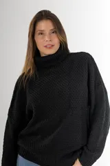 Sweater negro tejido en punto arroz, con cuello alto, mangas largas y silueta holgada.