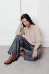 Sweater fucsia de tejido suave y ligero, con calce relajado, costura central y terminaciones acanaladas.