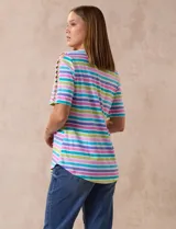 Remera de algodón a rayas horizontales en tonos rosa, celeste, verde y lila. Tiene cuello redondo y mangas cortas con detalle de entrelazado y aberturas en los hombros.