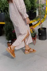 Sandalias de cuero color marrón y blanco, con suela track negra y ajuste con velcro.