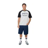 Remera blanca con mangas raglán negras y estampado frontal con el logo de Rusty en azul.
