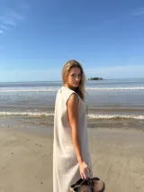 Vestido midi sin mangas color beige, con corte recto y detalle de franja vertical marrón en el centro.