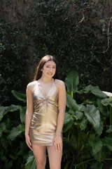 Vestido corto de fiesta color lila metalizado, con escote en V, breteles finos, cut-outs en la cintura y falda ajustada con cordones laterales.